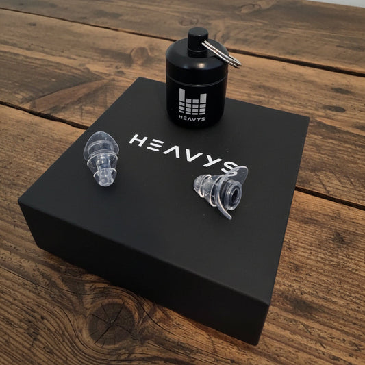 Heavys H1F1 earplugs with their metal carry case on the box