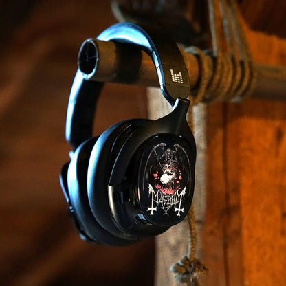Black over-ear headphones with a skull-and-crossbones graphic on the earcup, hanging from a rope on a rustic wooden post.-1 heavys h1h headphones MAYHEM